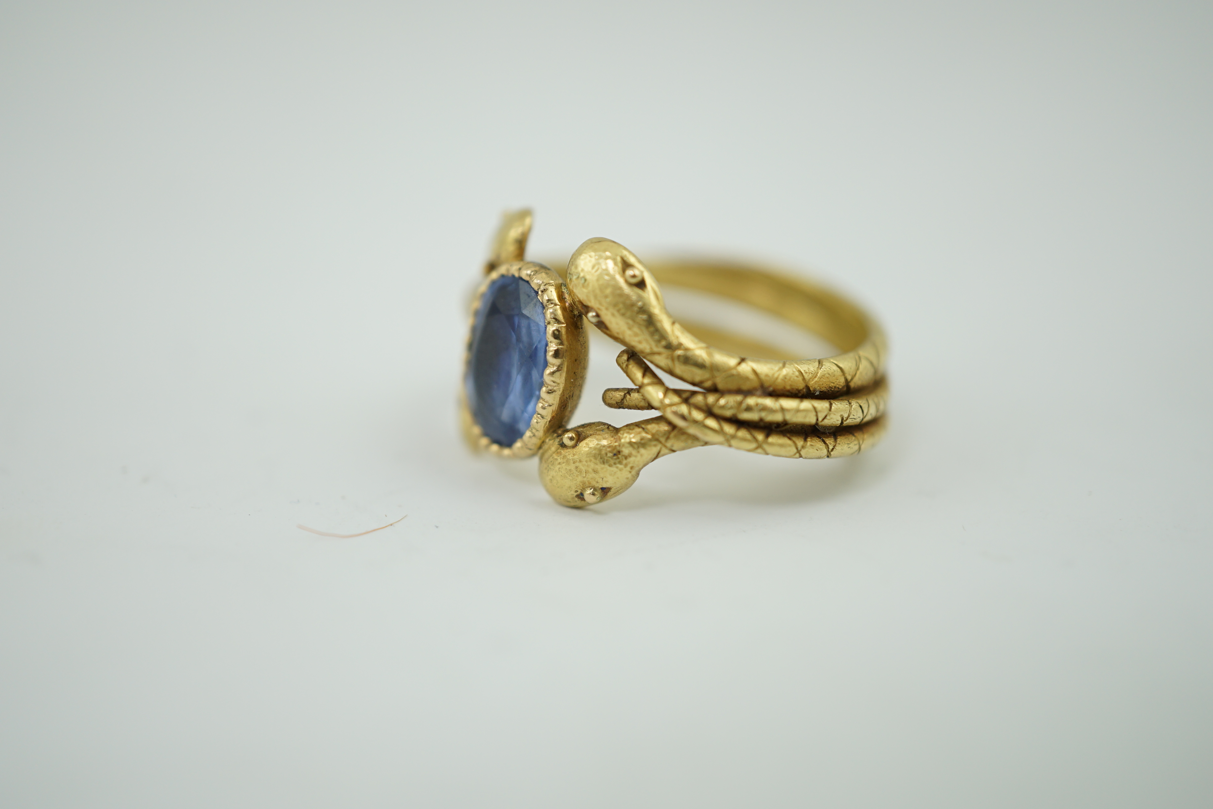 A late 19th century American Marcus & Co gold and single stone oval cut Sri Lankan sapphire set serpent ring